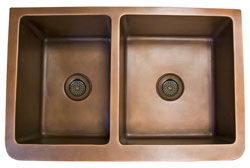 Double bowl copper farmer sink with stylized flower motif